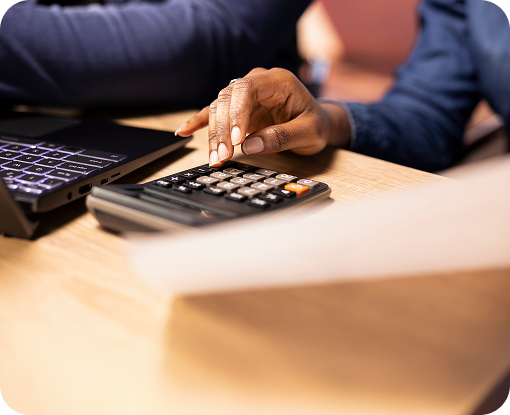Close-up of hands using a calculator on a desk