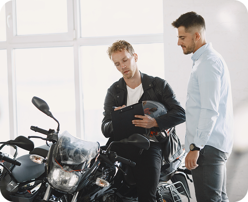 Two people talking beside a motorcycle