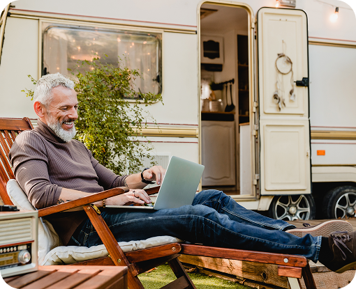 A person relaxing in a chair beside a motorhome