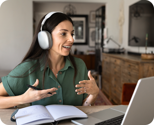 A person wearing headphones on a video call at a laptop