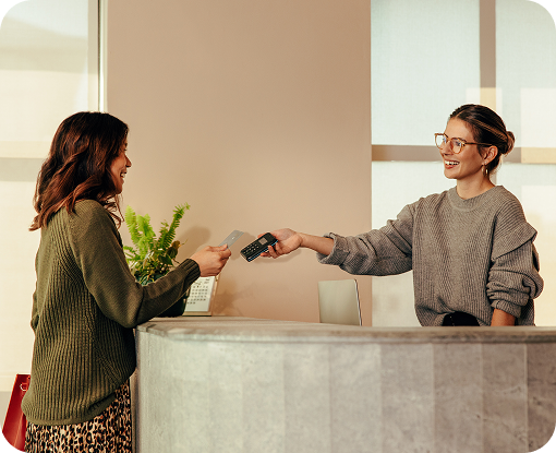 A customer handing a payment card to a shop assistant