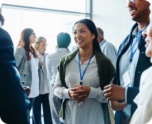 A group of people wearing name badges talking together at an event