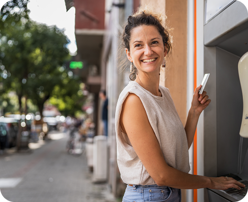A person smiling outdoors on a tree-lined street