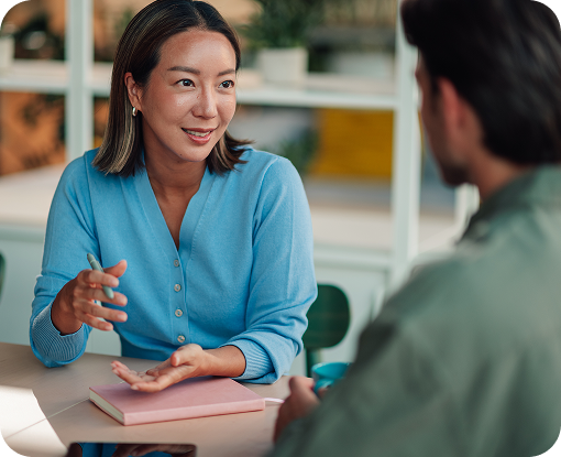 Two people talking across a table during a meeting