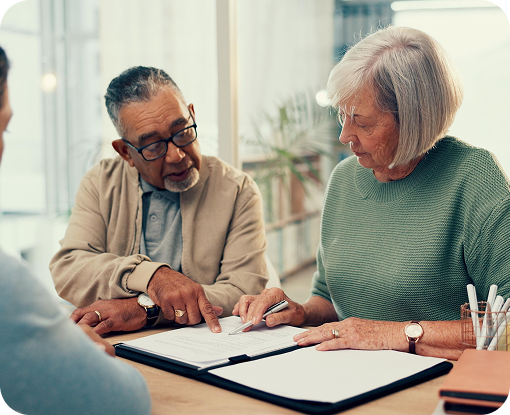 Three people reviewing paperwork around a table