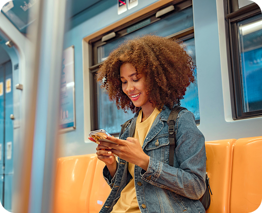 A person using a phone beside a train