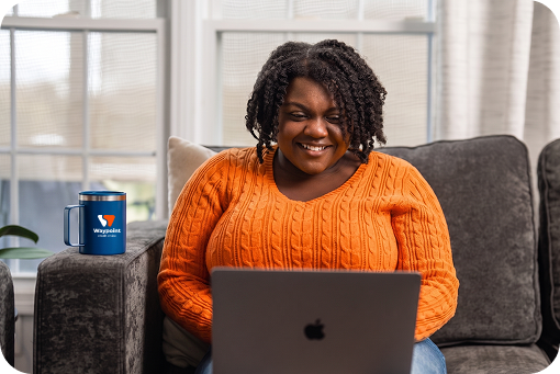 A person using a laptop in an armchair