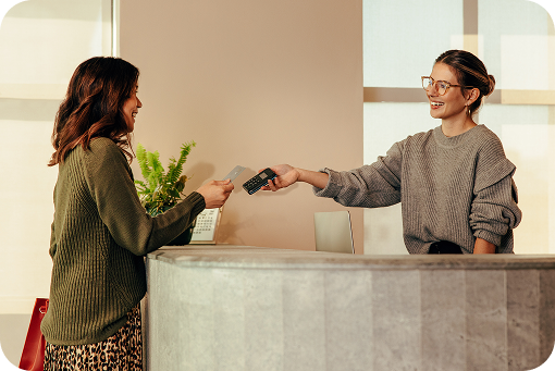 A customer handing a payment card to a shop assistant