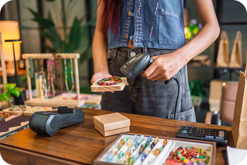 A shop worker using a card reader at a craft market stall