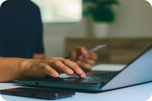 Close-up of hands using a laptop and a payment card