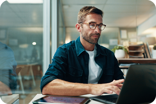 A person working at a laptop in a bright office