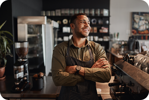 A small business owner standing with folded arms in their shop