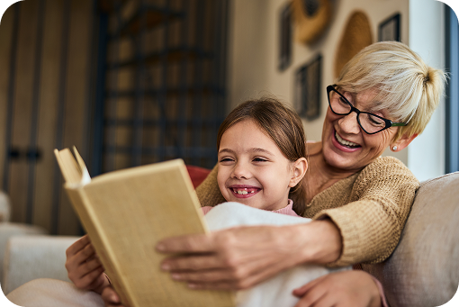 A grandparent and child reading a book together