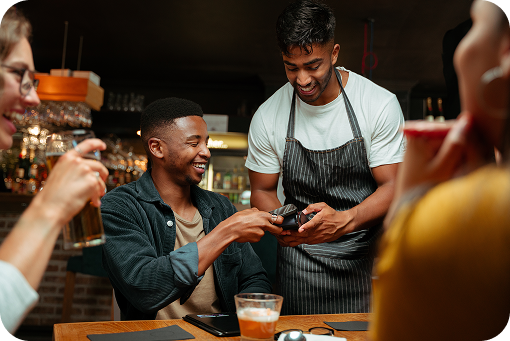 A customer paying by phone at a cafe counter