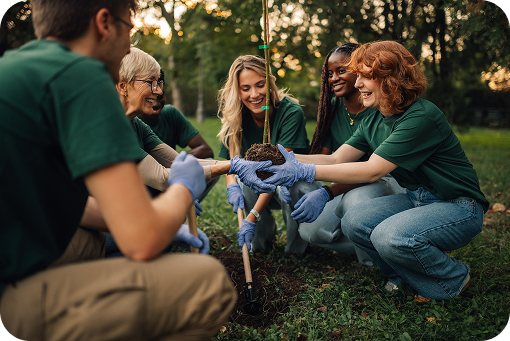 A group of volunteers in green shirts planting a tree outdoors