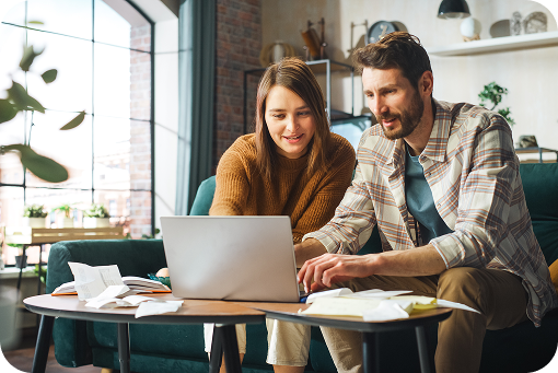 A couple reviewing paperwork together at a laptop