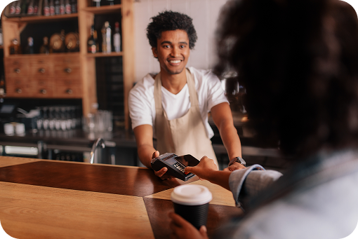 A shopper paying by card at a cafe counter