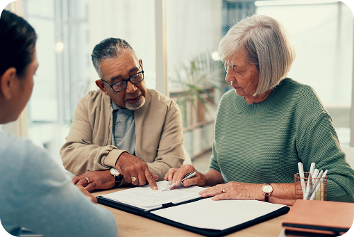 Three people reviewing paperwork around a table