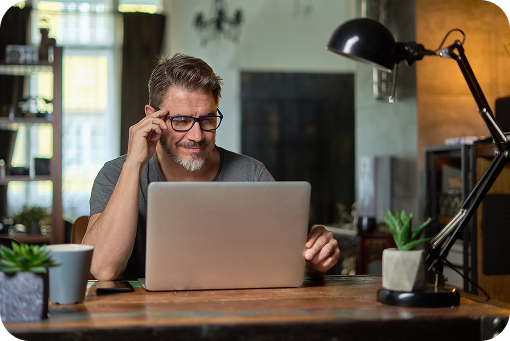 A person on the phone at a desk with a laptop