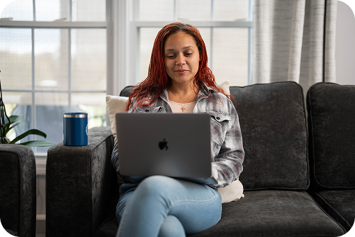 A person using a laptop on a sofa