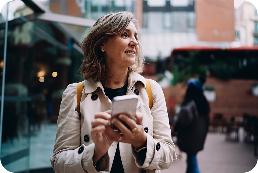 A traveller using a phone on a city street
