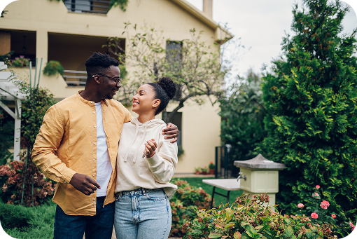 A couple standing together outside a house