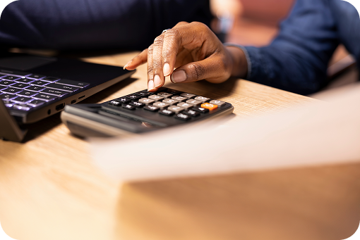Close-up of hands using a calculator on a desk