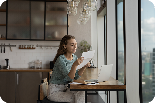 A person working at a laptop at a kitchen counter