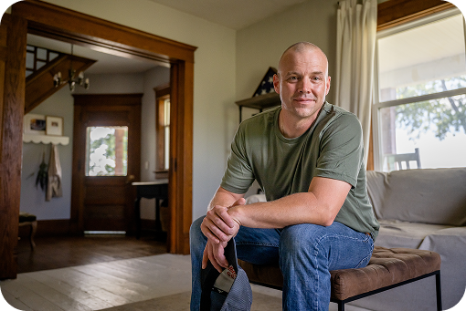 A person sitting in the doorway of a home