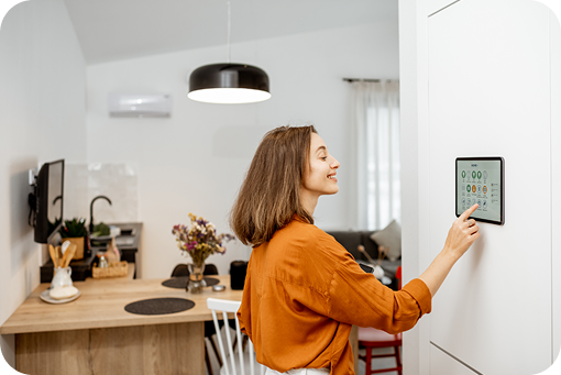 A person adjusting a smart thermostat on the wall