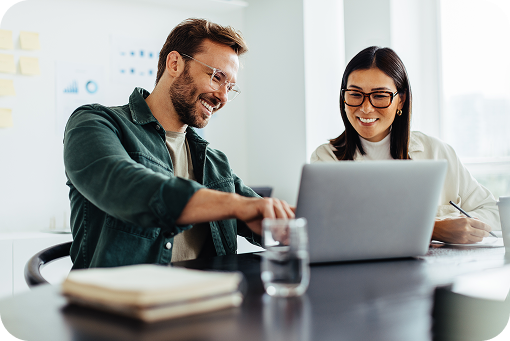 Two people working together at a laptop in an office