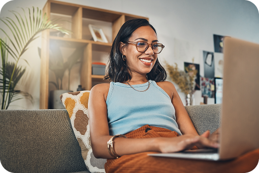 A person smiling while working at a laptop