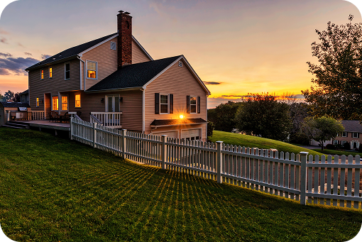 A house with a white picket fence at sunset