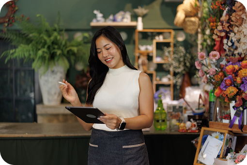 A person using a tablet in a florist's shop