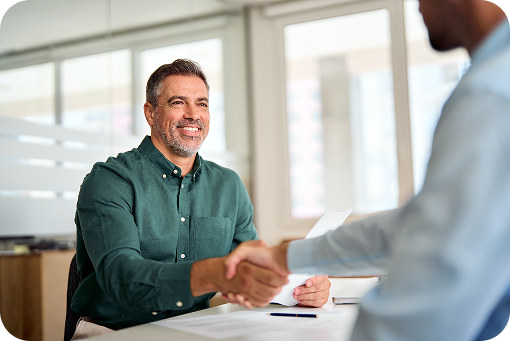 Two people talking across a desk in an office