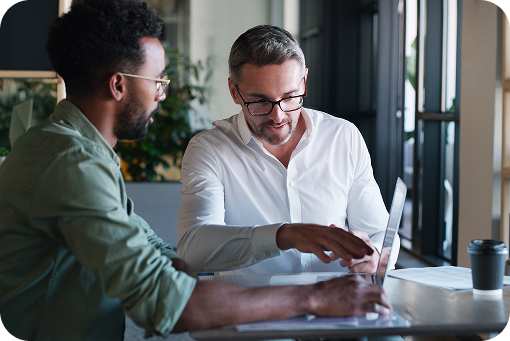 Two people talking over documents at a table