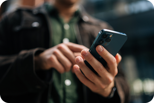 Close-up of a person holding a smartphone outdoors